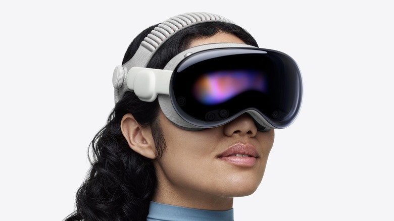 A person wearing the Apple Vision Pro headset, showcasing the external cameras and sensors used for spatial mapping.