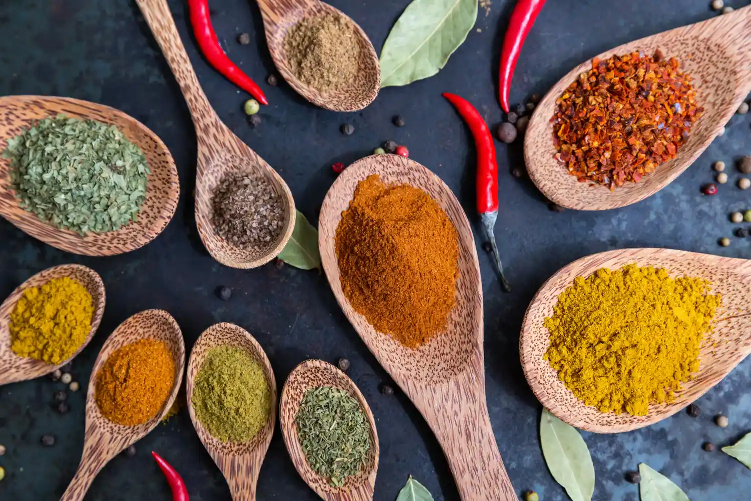 Multiple small piles of various ground spices and dried herbs.