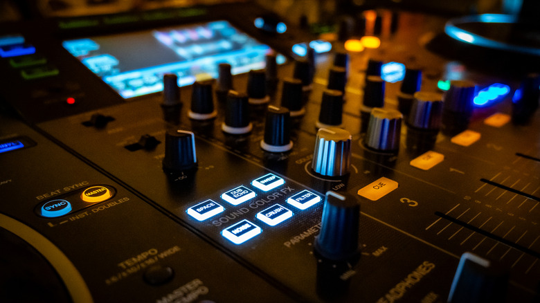 Close-up detail of faders and knobs on a professional audio mixer.
