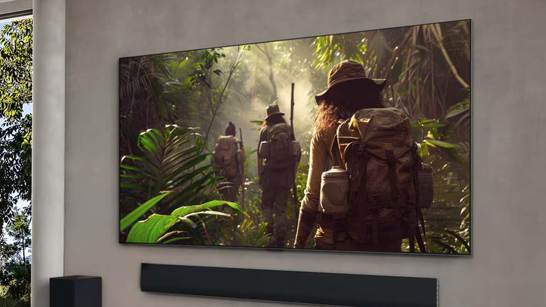 A man looking at the sleek LG G5 OLED TV.