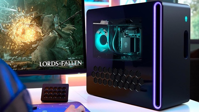 Alienware Aurora gaming PC showing its internal lighting next to a monitor.