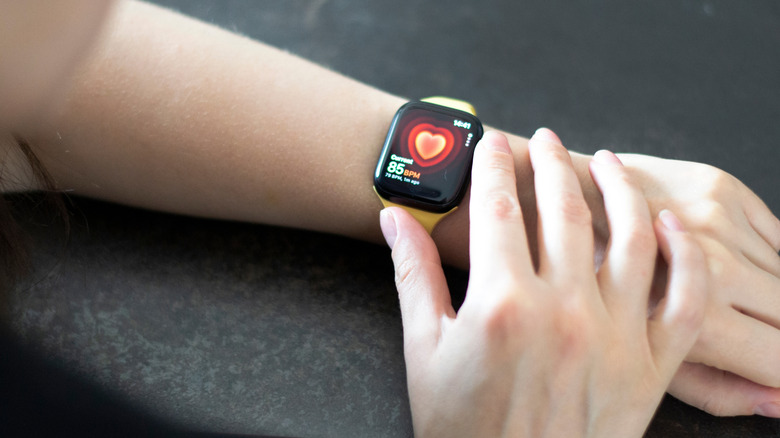 An Apple Watch Series 8 displaying heart rate tracking information on the screen.