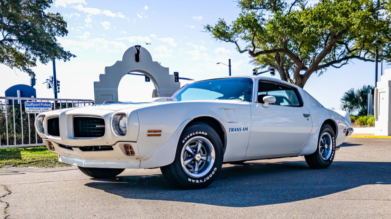 A pristine white 1973 Pontiac Firebird Trans Am featuring the iconic bird hood decal.