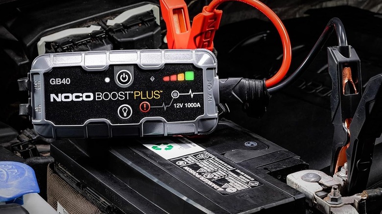 NOCO Boost GB40 jump starter with its clamps attached to a vehicle battery.