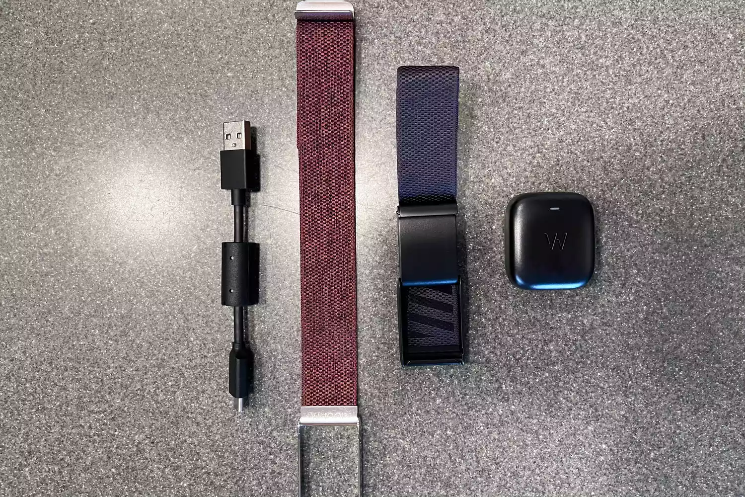 Flat-lay of Whoop accessories including multiple bands, a battery pack, and charging cables.
