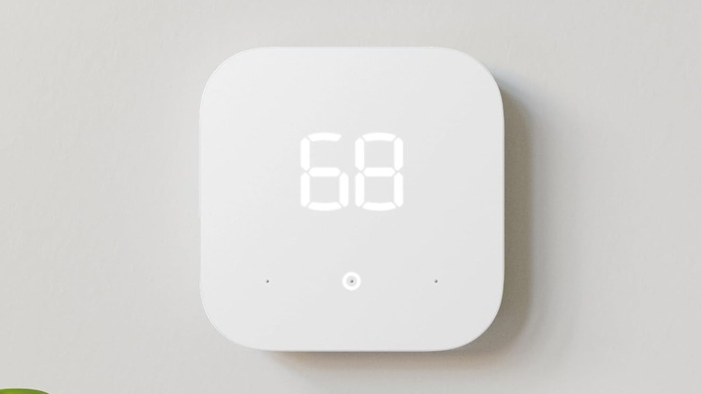 White Amazon Smart Thermostat mounted on a plain wall showing basic temperature controls.