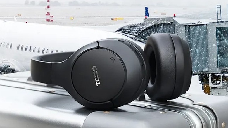 TOZO HT2 wireless headphones resting on a piece of luggage.