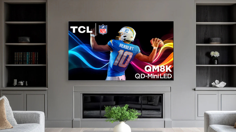 The TCL QM8K Mini-LED TV in a modern living room.