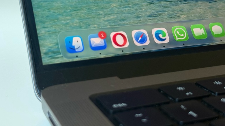 A close-up view of the macOS Tahoe dock icons on a MacBook Pro screen.