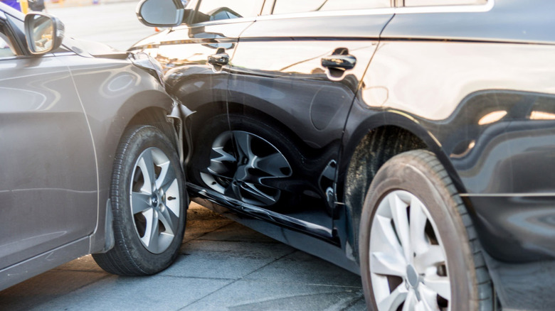 A visual representation of a car accident showing a gray car colliding with a black car.